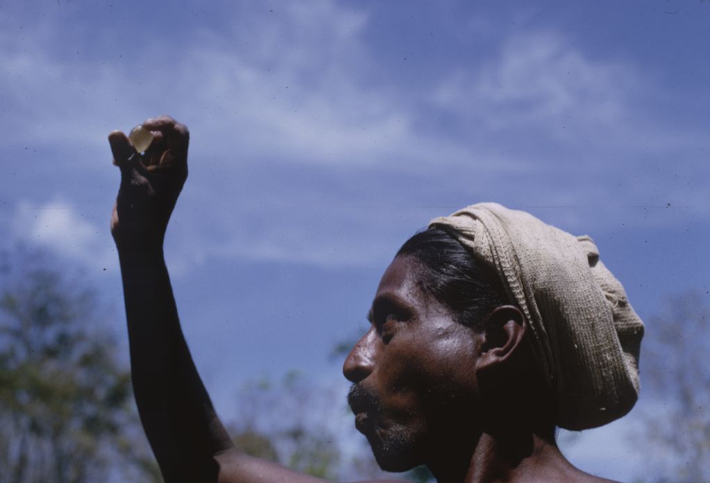 Ceylon (Sri Lanka), A Singalese miner inspects a gemstone against the sky