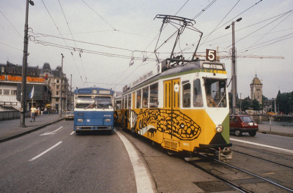 Zurich, VBZ streetcar Be 4/4 1400 (Zoo streetcar) on the station bridge, next to it the VBZ trolleybus 76