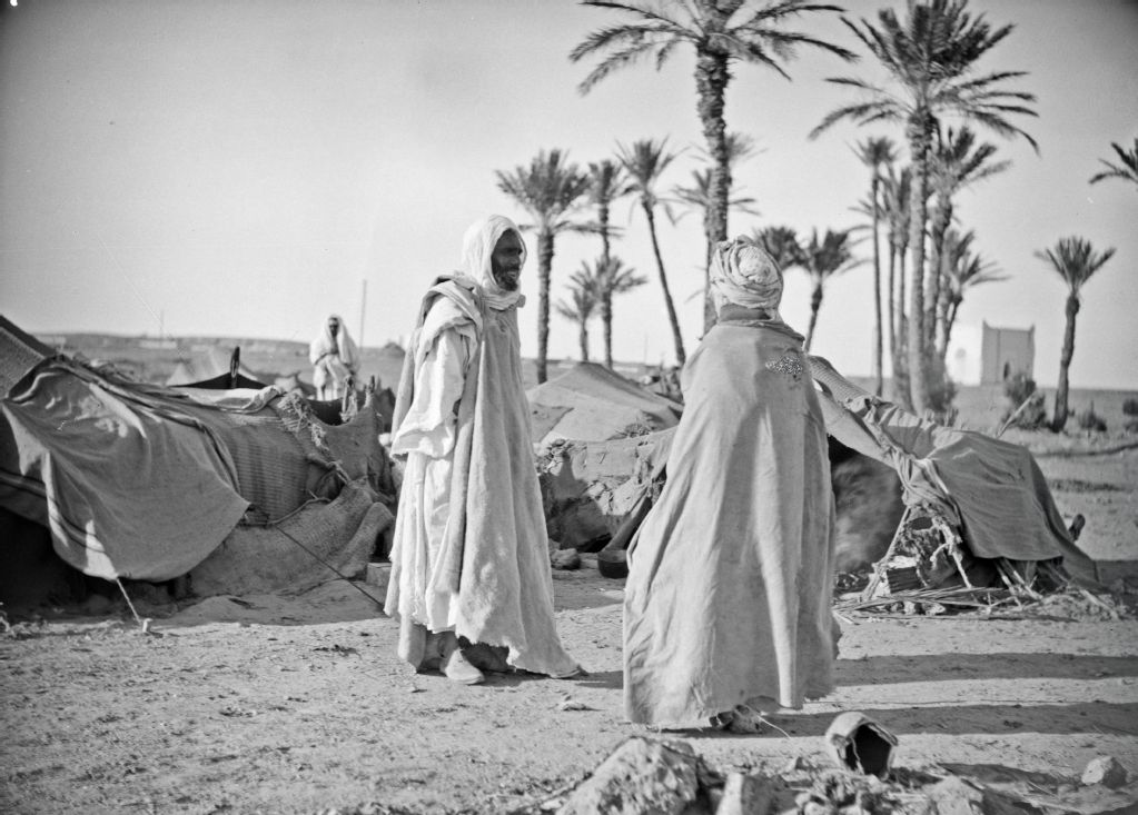 Men in front of tents in an oasis