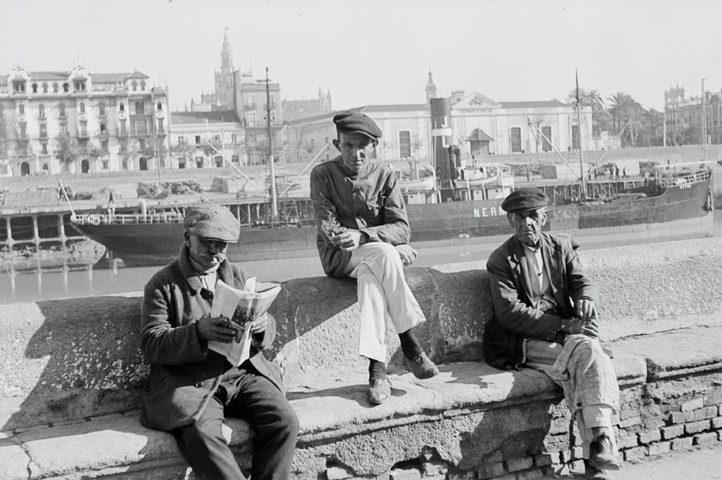 Three men on the banks of the Guadalquivir River in Seville