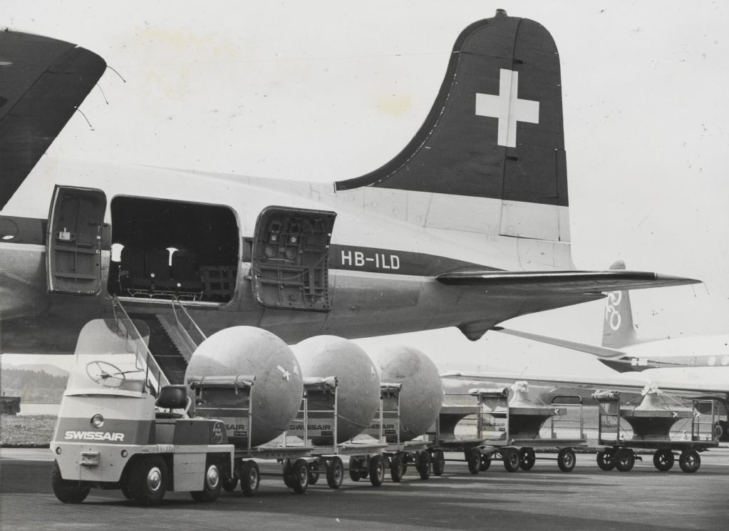 Cargo loading of sewage treatment plants into Balair's Douglas DC-4-1009, HB-ILD at Zurich-Kloten