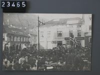 Bergen, crowd on the square Torgallmenningen, with company names on house facade: Ferd. Storjohanns Sönner, Sagförnerne Martens