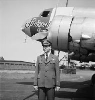 Swissair on-board radio operator Paul Auberson in front of a Douglas DC-2 of Swissair with neutrality painting