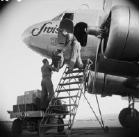Cargo loading into the forward stowage compartment of a Douglas DC-2 of Swissair in Dübendorf