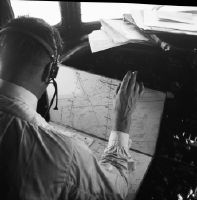 Swissair co-pilot with "Blechesel" (radio navigation maps glued to aluminum plates and bound together with spiral stitching)