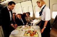 Flight attendants serving meals in the economy-class cabin of a Swissair Boeing 747