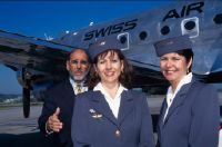 Pilot Leander Ritzi and hostesses in front of the Douglas DC-4-1009 A, HB-ILI "Basel/Schwyz" in Geneva-Cointrin