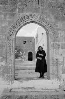 Rhodes, Lindos, old woman in the gate to an inner courtyard